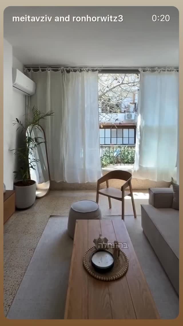 Minimalist Scandinavian living room with sheer curtains, wood coffee table, gray sofa, plant and mirror, bright natural light