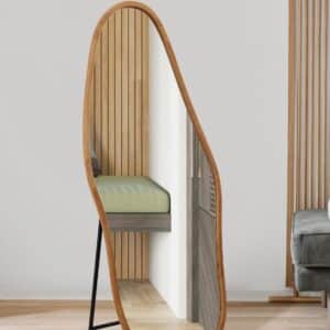 Organic asymmetrical full-length standing floor mirror with wood frame in modern living room, minimalist decor.