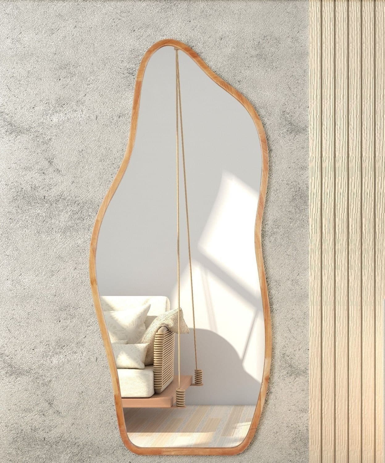 מראה אמורפסית רחבה (1) Organic wavy full-length mirror with wood frame reflecting rattan sofa and indoor swing in neutral boho living room.