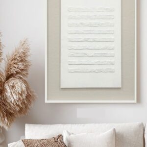 Scandi boho living room with textured white abstract wall art, beige sofa, cream pillows and pampas grass decor.