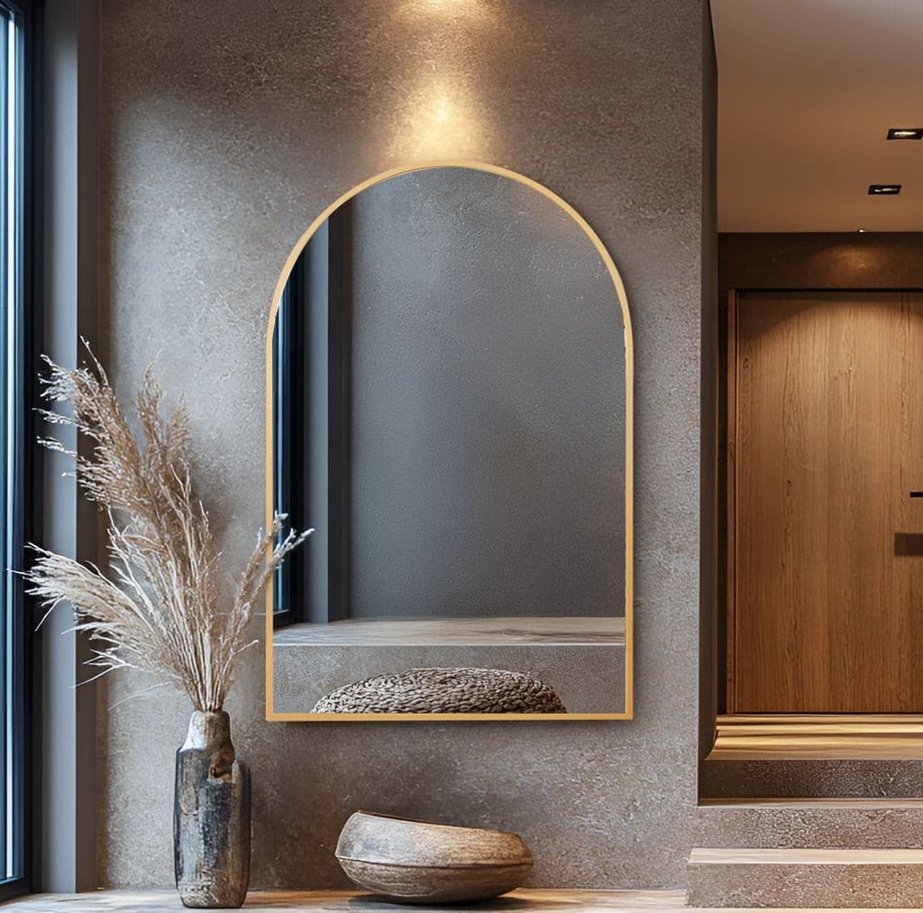 V6H5M5Xr Modern entryway with arched gold-framed mirror, pampas grass vase, and minimalist stone textures in warm neutral decor.